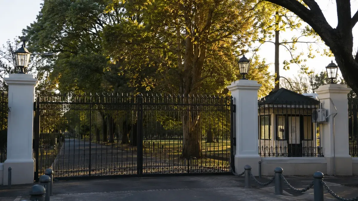 Portón de hierro de acceso a la Quinta de Olivos con parque de fondo
